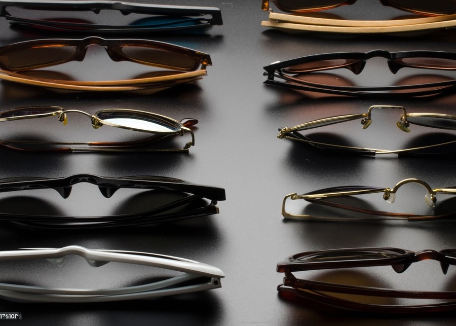 A display of eyewear frames made from different materials like acetate, metal, and titanium.