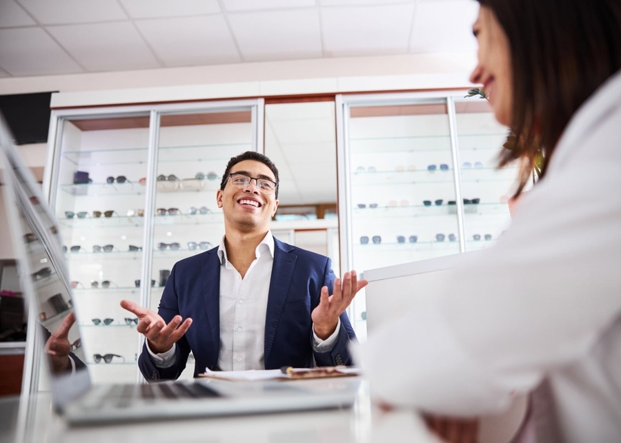 A person in a meeting asking pointed questions to an eyewear manufacturer representative.